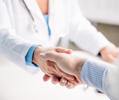 mujer médico le da la mano a paciente