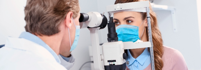 médico frente a paciente realizando examen oftalmológico