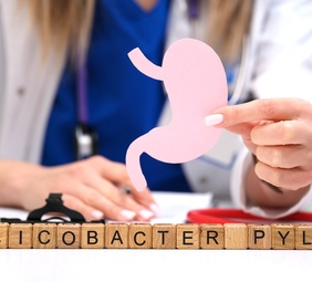 consulta médica, letras forman la palabra helicobacter pylori en cubos de madera