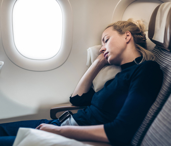 persona durmiendo en un avión con luz de día
