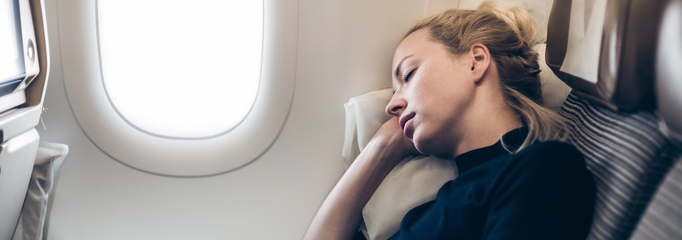 persona durmiendo en un avión con luz de día