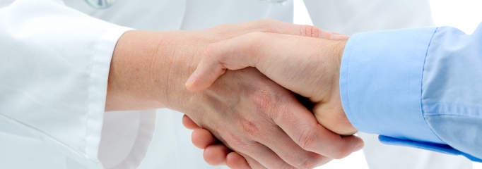 médico y paciente hombre se dan la mano