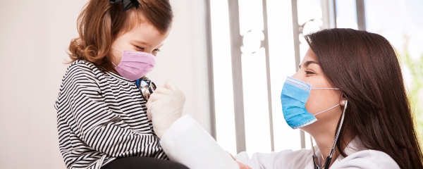 niña pequeña se rie junto a su doctora