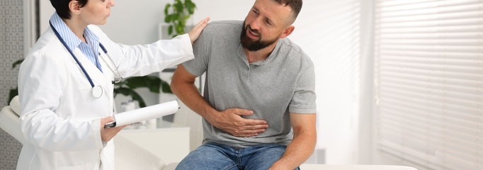 persona con dolor abdominal por úlcera péptica en consulta médica